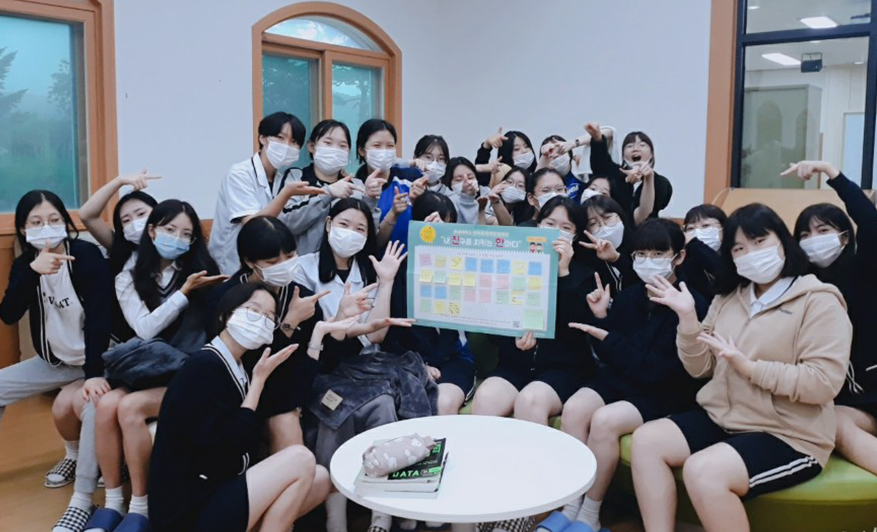 육민관고등학교 3학년 4반 친구들이 옹기종기 모여 언어폭력예방캠페인 활동판을 들고있는 사진