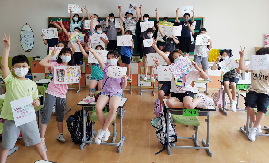 서원주초등학교 4학년 1반 친구들이 책상에 앉아 각자 사이버폭력예방을 표현한 그림을 들고 있는 사진
